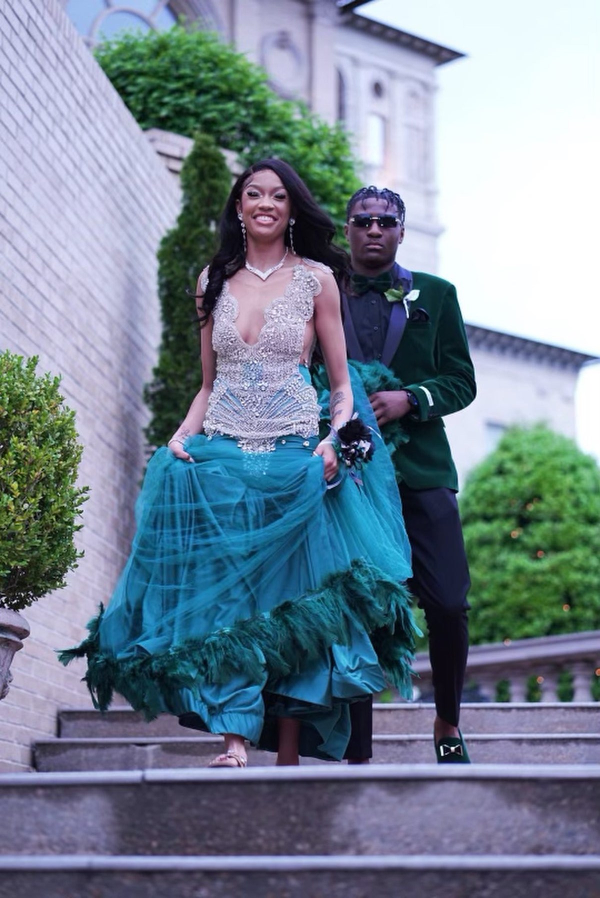 Gechi Signature's client donning her Green floor length mermaid Prom dress, accompanied by a gentleman.